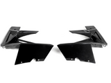 Two black carbon fiber car parts face each other, showcasing sleek, angular designs on a plain white background.