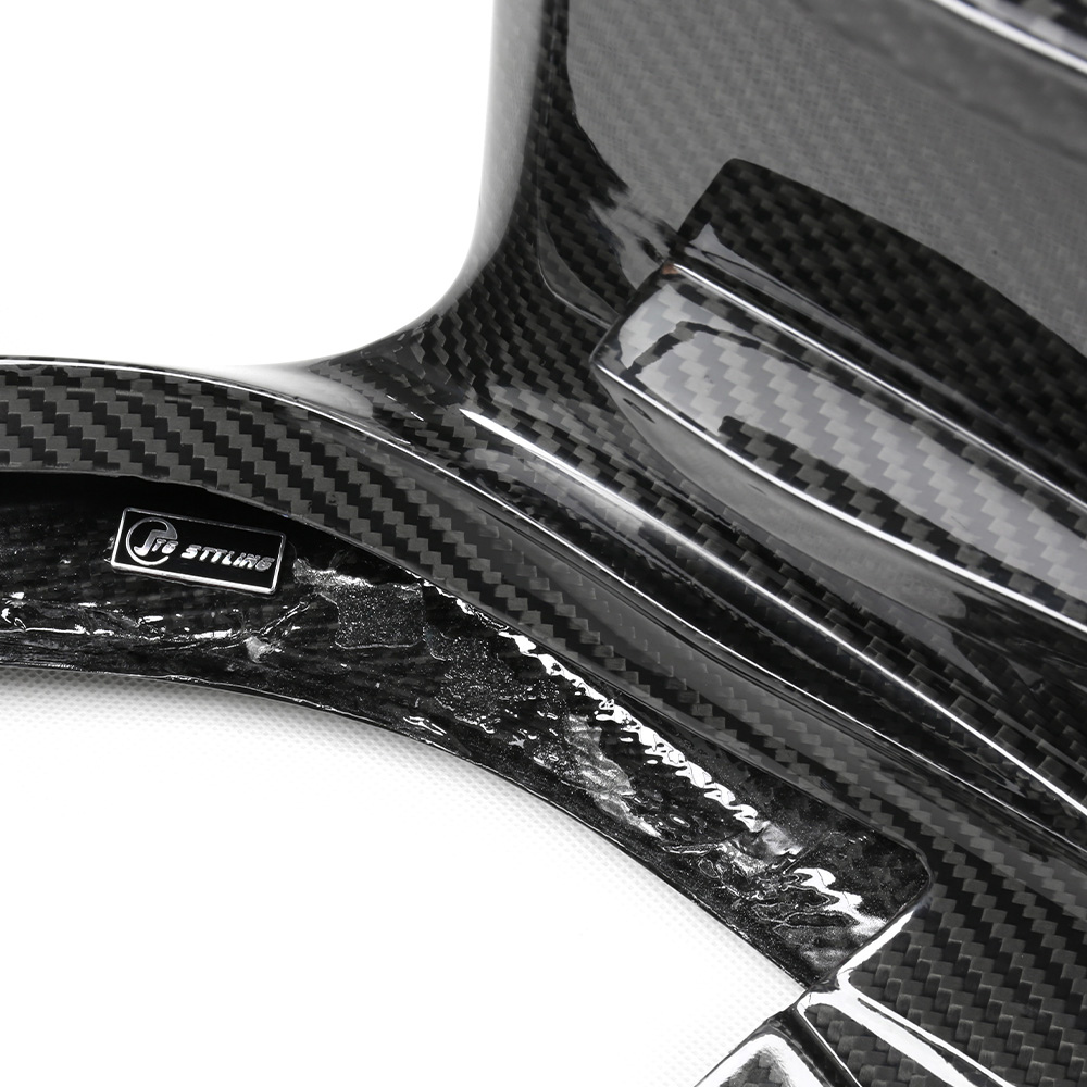 Carbon fiber material with "CT STYLING" label, showing glossy, textured surface. The item appears to be a component or cover, likely automotive, with visible weave pattern in a studio setting.