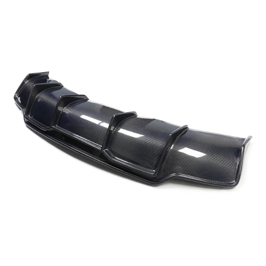 A black carbon fiber car rear diffuser with multiple vertical fins rests on a plain white surface, highlighting its aerodynamic design.