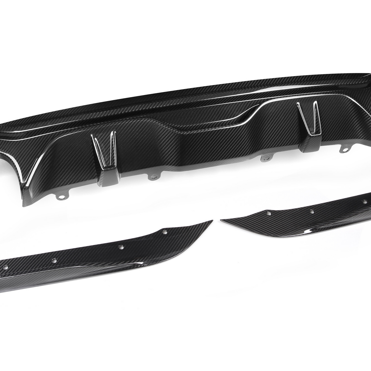 Carbon fiber car diffuser, disassembled, resting on a white background. Two smaller side pieces complement the main central component, showcasing a sleek, aerodynamic design with a shiny finish.