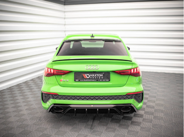 A bright green sports car is parked in a showroom with textured walls. It features the Audi logo above the license plate, which reads “MAXTON design” and “www.AudiCenterKarl.cz / 604 223 046.”