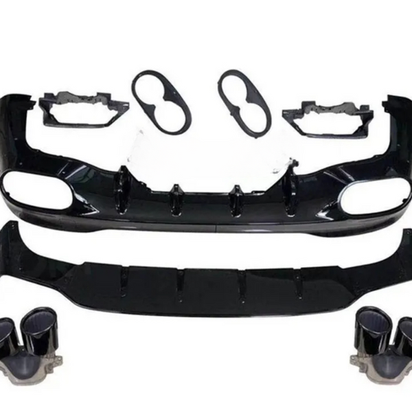 A disassembled car body kit includes a black front bumper with vent openings, a lower splitter, light bezels, and dual exhaust tips, arranged on a plain white background.
