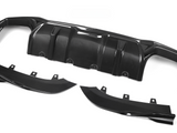 Carbon fiber car diffuser components lie on a white background. The main piece, with multiple ridges, is accompanied by two curved side parts, each featuring mounting brackets.