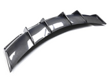 A curved carbon fiber car diffuser, featuring a series of vertical fins, rests on a plain white background.
