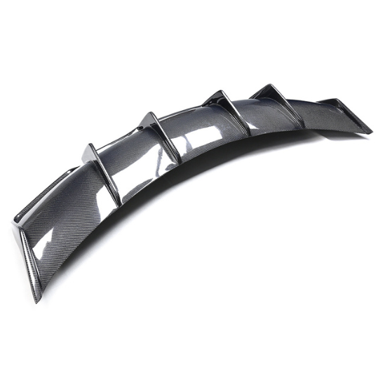 A curved carbon fiber car diffuser, featuring a series of vertical fins, rests on a plain white background.
