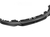 A carbon fiber car bumper with vent openings and mounting holes, positioned on a white background. The brand name 