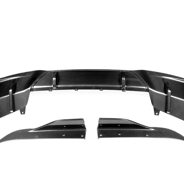 Carbon fiber car parts are displayed on a white background. The main piece is curved, with detailed patterns, and two smaller side components, aligning symmetrically below it.