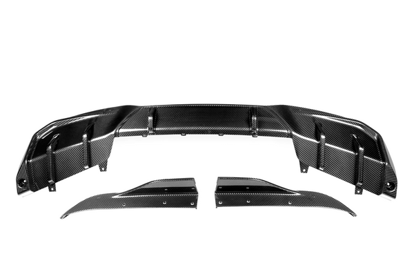 Carbon fiber car parts are displayed on a white background. The main piece is curved, with detailed patterns, and two smaller side components, aligning symmetrically below it.