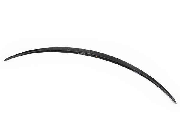 A sleek, black carbon fiber car spoiler is shown resting against a plain white background, with text "AMG" visible.