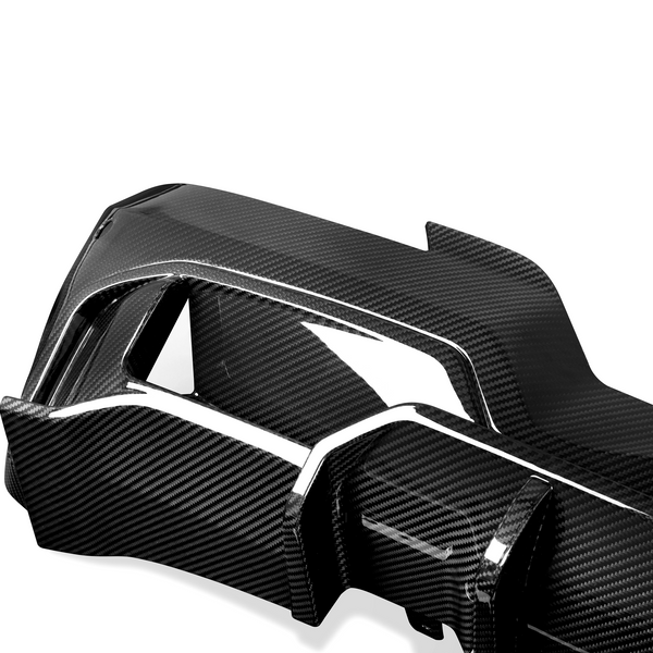 A sleek carbon fiber car part with a glossy finish, featuring angular sections and cutouts, set against a plain white background.