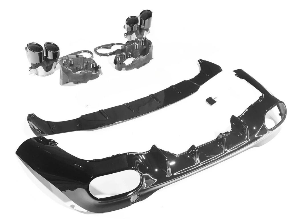 Car bumper parts are laid out, including a black bumper with cutouts, two cylindrical exhaust tips, and a splitter, on a white background, ready for assembly or display.
