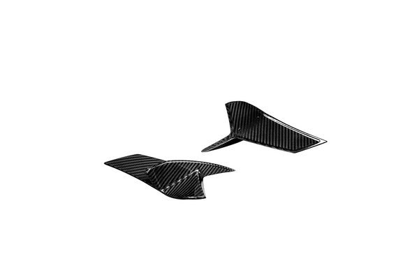 Two black carbon fiber fins rest on a white background, showcasing their textured, glossy surface.