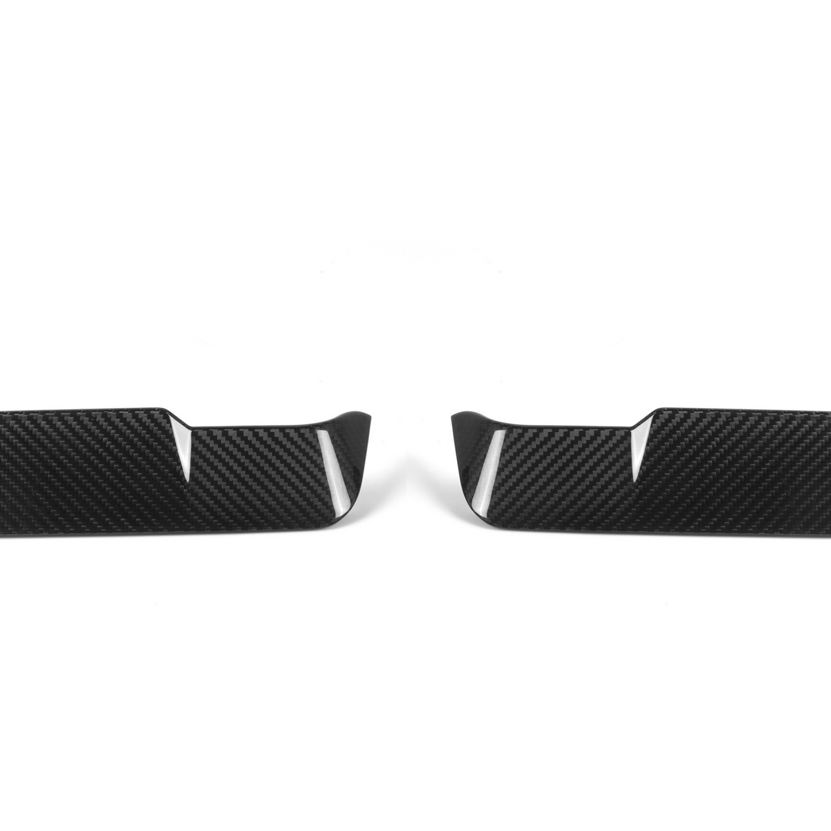 Two black carbon fiber car trim pieces lie side by side, each featuring a sleek, angular design with vertical slits, set against a plain white background.