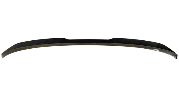 A black, curved car spoiler lies flat against a plain white background, showcasing its sleek aerodynamic design and glossy finish.