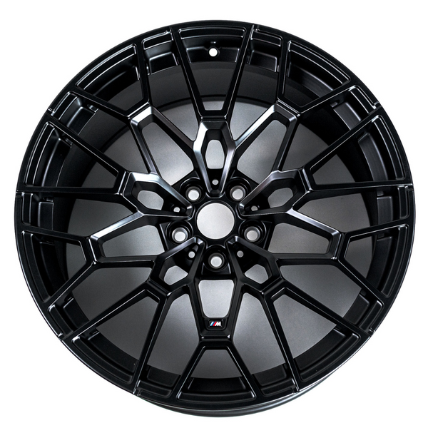 A black alloy wheel features a complex, multi-spoke design. It's displayed against a plain, white background. There is a small logo with the letter "M" in color.
