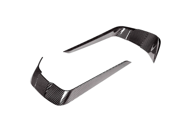Two curved carbon fiber trim pieces, reflecting light, positioned apart on a white background. They are designed for vehicle detailing.