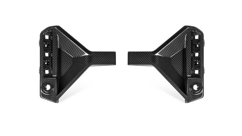 Two carbon fiber car parts, symmetrically placed facing each other, with multiple cut-out sections and glossy surfaces, set against a plain white background.