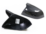Two carbon fiber car mirror covers lie on a white background, one showing the inner side with a label reading 