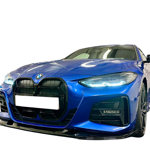A blue BMW car is parked on a reflective surface, showcasing its sleek design and illuminated headlights. The background is a plain, dark setting, highlighting the vehicle's features.