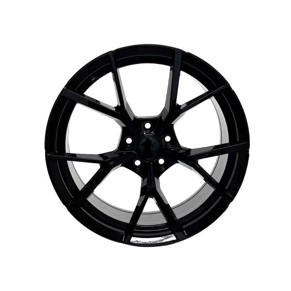 A glossy black alloy wheel with a multi-spoke design is displayed against a plain white background, highlighting its symmetrical, intricate structure and metallic finish.