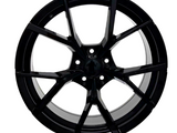 A glossy black alloy wheel with a multi-spoke design, symmetrically arranged, against a plain white background, showcasing its sleek and modern appearance.