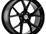 A black alloy wheel with a multi-spoke design features a central emblem with 