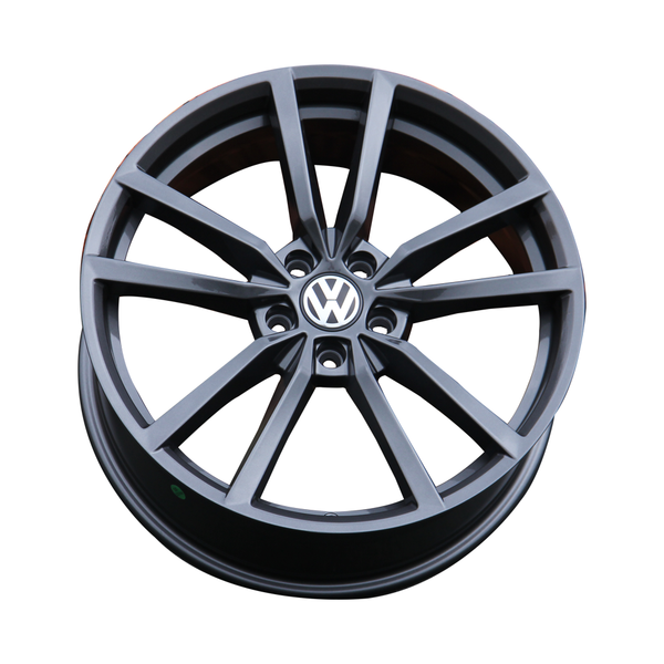 A black alloy wheel, featuring the Volkswagen logo in the center, is displayed against a plain white background.