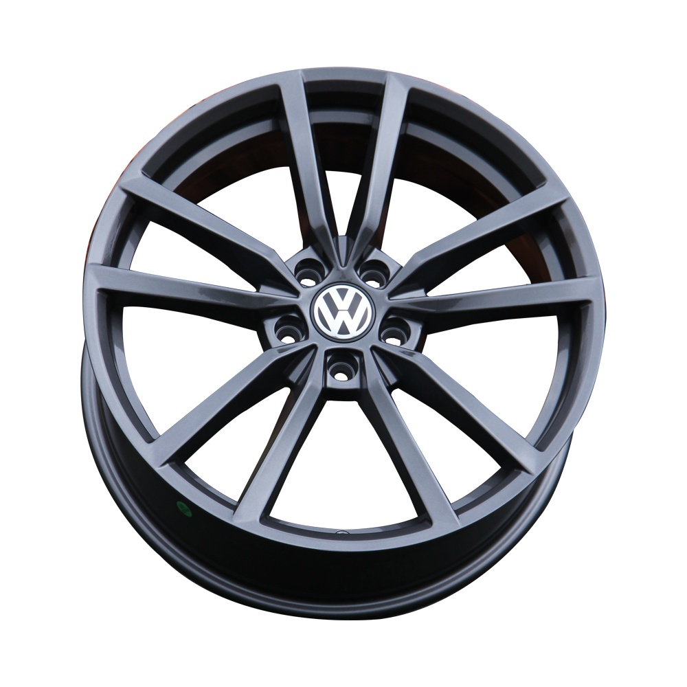 A metallic black wheel rim with a central logo, featuring a star-shaped spoke design, is isolated on a white background, showcasing its intricate structure and sleek finish.