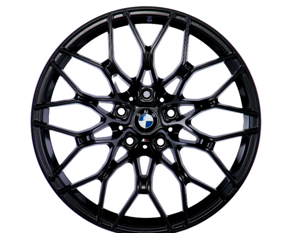 A black, multi-spoke alloy wheel with a central BMW logo, displayed against a plain white background, showcasing intricate design and structure.