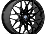 A black, multi-spoke alloy wheel with the BMW logo at the center, displayed against a white background.