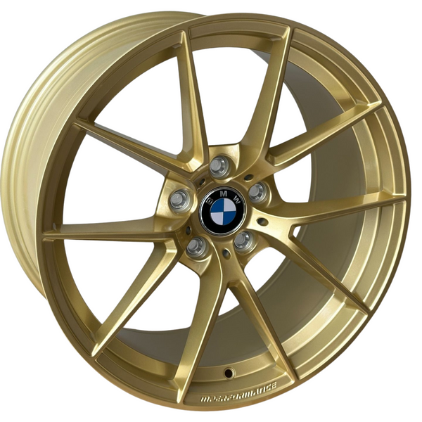 A gold alloy wheel, featuring a five-spoke design, displays a BMW emblem at the center. Raised text near the rim edge reads "M PERFORMANCE." The wheel is isolated on a plain background.