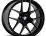 A black BMW alloy wheel with a multi-spoke design is positioned against a plain white background, highlighting its sleek and polished appearance. The BMW logo is visible at the center.