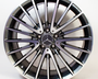 A chrome-finished wheel rim with a Mercedes-Benz logo at the center features sleek, multi-spoke design. The context is a plain white background, showcasing the brand's emblem.