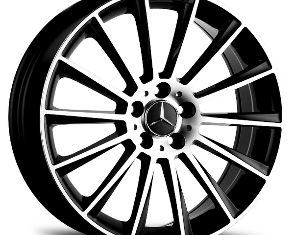 A silver and black alloy wheel features multiple spokes radiating from a central hub with a logo. Text reads "AMG" on the edge. Set against a white background.