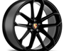 A black alloy wheel with a five double-spoke design, featuring the Porsche crest at its center, is positioned on a white background.