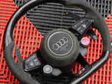 Steering wheel featuring Audi logo and controls like 