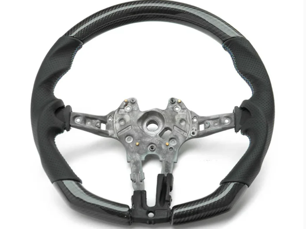 A partially assembled car steering wheel is shown, featuring a metallic central frame with exposed wiring, surrounded by a two-tone black and grey perforated leather grip, against a plain white background.