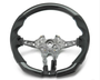 A partially assembled car steering wheel is shown, featuring a metallic central frame with exposed wiring, surrounded by a two-tone black and grey perforated leather grip, against a plain white background.