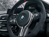 Steering wheel with BMW logo features a sleek design and controls. It's set against a car dashboard with raindrops visible on the windshield, implying a rainy day outside.