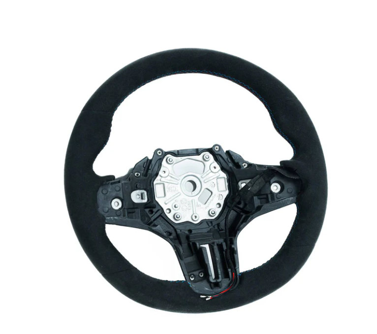 A black car steering wheel sits isolated against a white background, featuring an exposed central mechanism with screws and a textured circular outer grip.