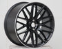 A black alloy car wheel with intricate spoke design rests on a plain white surface against a tiled white background, emphasizing the wheel's sleek, modern appearance.