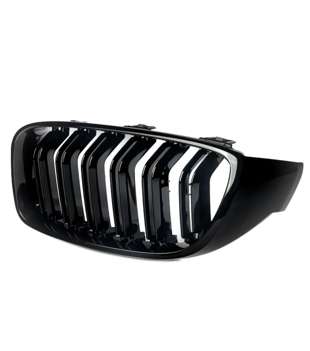 A glossy black car grille features vertical slats with a chrome finish, against a plain white background, designed for the front of a vehicle.