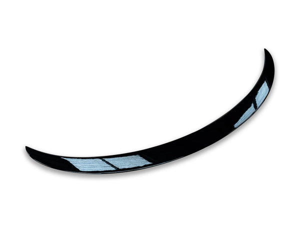 Curved black object with two light blue reflective sections, resembling a car spoiler or aerodynamic component, set against a plain white background.