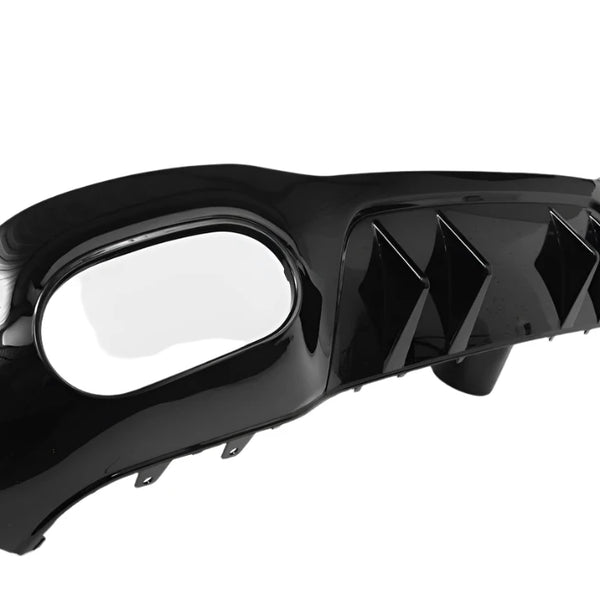 A shiny black car rear diffuser with three vertical fins sits on a white background, featuring an oval exhaust cutout on one end.