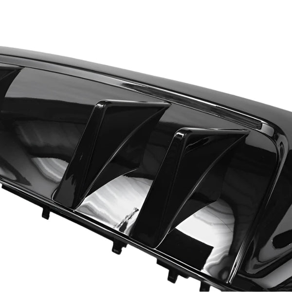 Shiny black car part with multiple fins, likely a diffuser or spoiler, reflecting light; positioned against a plain, neutral background.