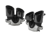 Two shiny black dual exhaust tips, mounted on metallic bases, are displayed on a plain white background. They have a sleek, curved design and multiple attachment points.