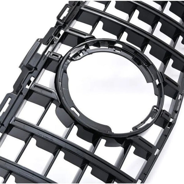 A black plastic grille featuring a series of rectangular openings surrounds a central circular cutout, set against a plain white background.