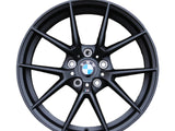 A black alloy wheel with a multi-spoke design features a BMW emblem in the center. The text 