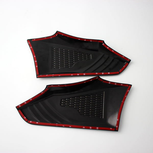 Two black plastic panels with textured surfaces, outlined by red trim tape, are positioned side by side on a plain white background.