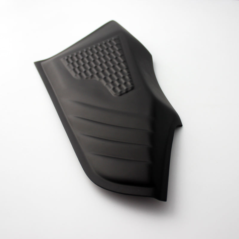 A black, textured rubber pad with diagonal grooves and a grid pattern, lays on a flat, white background.